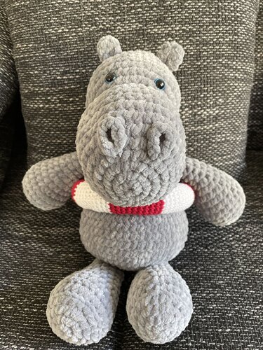 Grau gehäkeltes Nilpferd-Amigurumi mit rotem und weißem Schwimmring, frontal