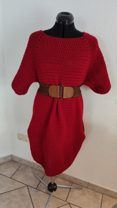 Rotes gehäkeltes Damenkleid auf Schneiderbüste mit braunem Gürtel
