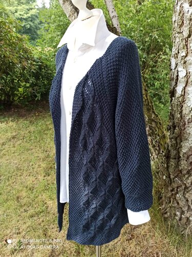 Dunkelblaue offene Strickjacke mit Zopfmuster auf Schaufensterpuppe im Freien