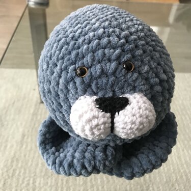 Gehäkelte graublaue Robbe Amigurumi mit weißer Schnauze und schwarzen Augen
