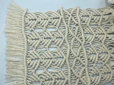 Detailaufnahme cremefarbenes Makramee mit Knotenmuster und Fransen