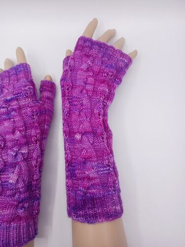 Fingerlose Armstulpen in Pink-Violett mit Zopfmuster an ausgestellten Armen
