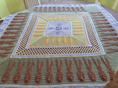Quadratisches gehäkeltes Deckchen in Pastellgrün, Braun und Flieder mit Karotten- und Hasenmotiven und Netzbordüre