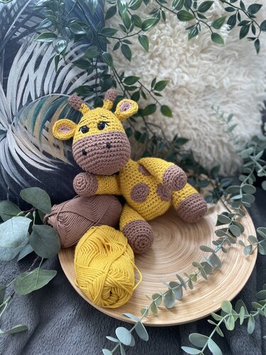 Detailaufnahme einer gehäkelten Amigurumi-Giraffe mit sichtbaren Maschen und zwei Garnknäueln