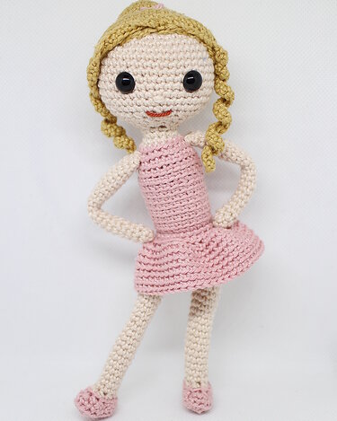 Gehäkelte Puppe mit rosa Kleid, goldblonden Zöpfen und schwarzen Augen