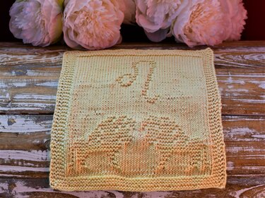 Quadratisches gestricktes Tuch in Pastellgelb mit eingestrickter Zahl 21 und Tortenmotiv