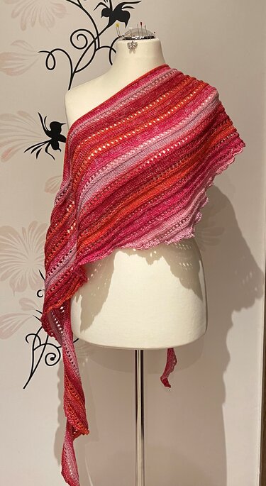 Asymmetrisches gestricktes Dreieckstuch in Rot- und Rosatönen auf Schneiderpuppe