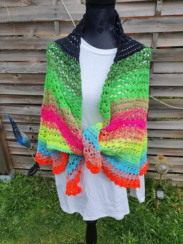 Gehäkeltes Tuch auf Schneiderpuppe mit Neon-Farbverlauf und dekorativem Lochmuster.