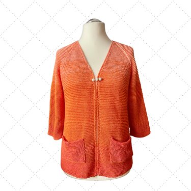 Orangefarbene Strickjacke für Damen mit Dreiviertelärmeln, zwei aufgesetzten Taschen und dekorativem Perlenverschluss auf einer Schneiderpuppe.