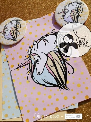 Stylized white unicorn with pastel mane and horn on pink paper with gold polka dots, next to two round unicorn buttons