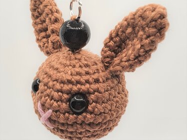 Gehäkelter brauner Hasenkopf mit schwarzen Perlenaugen und Aufhänger