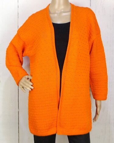 Mannequin trägt offene orange Strickjacke mit langen Ärmeln und mittlerer Länge