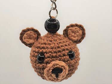 Gehäkelter brauner Teddybär‑Schlüsselanhänger mit schwarzen Perlenaugen an Metallring