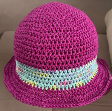Gehäkelter Hut in Magenta mit pastellfarbener Streifenborte