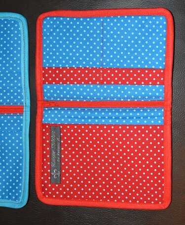 Innenansicht eines Portemonnaies mit horizontalen Einsteckfächern, mittigem Reißverschluss und zweifarbigem Punktestoff