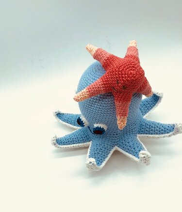 Hellblaue gehäkelte Krake mit korallenrotem Sternfisch auf dem Kopf