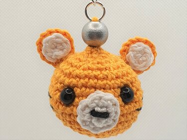 Oranger gehäkelter Tigerkopf‑Schlüsselanhänger mit weißer Schnauze und silberner Perle