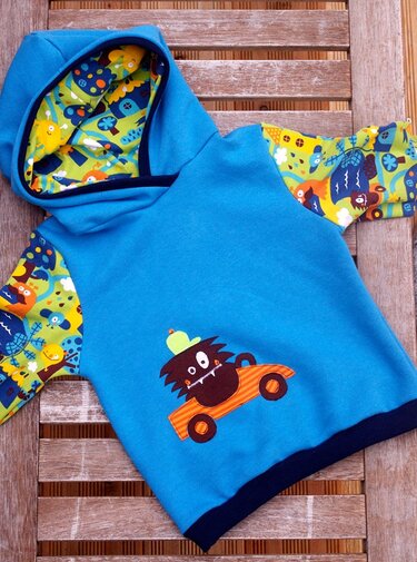 Blauer Kinder‑Hoodie mit Kapuze, appliziertem Monster im orangefarbenen Auto und bunten, gemusterten Ärmeln