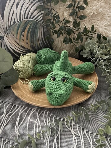 Grünes gehäkeltes Krokodil Amigurumi auf Holzschale mit Garnknäueln