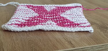 Rechteckiges gestricktes Muster in Weiß und Pink auf Holz