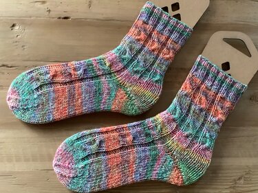 Paar handgestrickte mehrfarbige Socken mit Rippenbündchen auf Holzspannformen