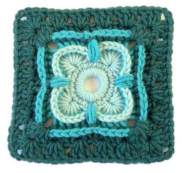 Gehäkeltes Granny Square mit vierblättriger Blüte in Türkis- und Petroltönen