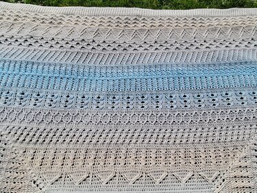 Gehäkelte Decke mit Beige‑zu‑Blau Farbverlauf und verschiedenen Häkelstichmustern
