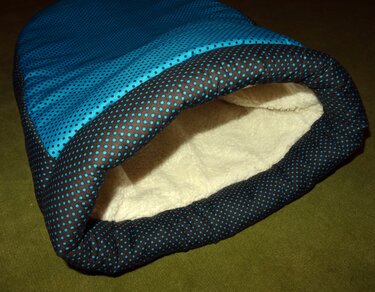 Türkisblauer Kuschelsack mit dunklem, gepunktetem Rand und cremefarbenem Plüschfutter