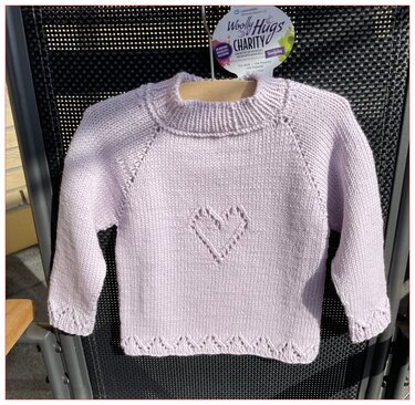 Zartlila gestrickter Babypullover mit Herzmotiv und Raglanärmeln