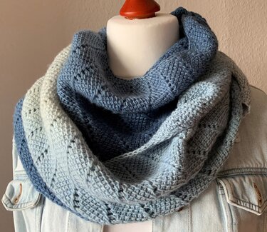 Gehäkelter Loop-Schal in Ombre-Blautönen auf Torso über Jeansjacke