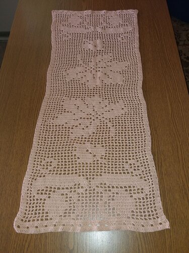 Pastellrosa Filet‑Tischläufer mit Blumen‑ und Blattmotiven auf Holztisch