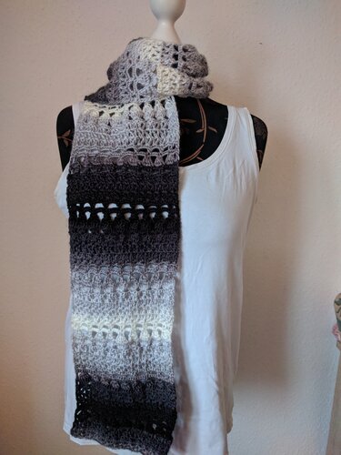 Langer, schmaler Häkel-Schal mit Lochstreifen und mehrstufigem Grauverlauf auf einer Büste