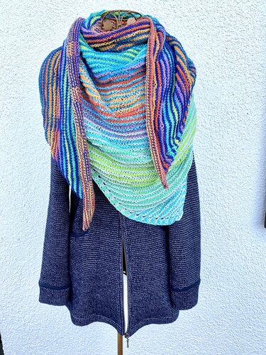 Buntes, gestricktes Dreieckstuch mit Farbverlauf über einer dunkelblauen Jacke auf Schneiderpuppe