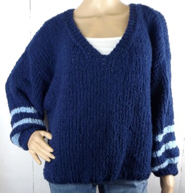 Grob gestrickter dunkelblauer Damenpullover mit V-Ausschnitt und hellblauen Streifen an den Ärmeln.