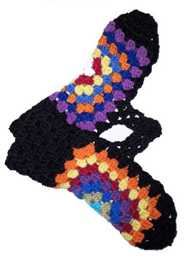 Zwei schwarze, gehäkelte fingerlose Handschuhe mit bunten Granny-Square-Motiven in Lila, Blau, Orange, Gelb und Rot.
