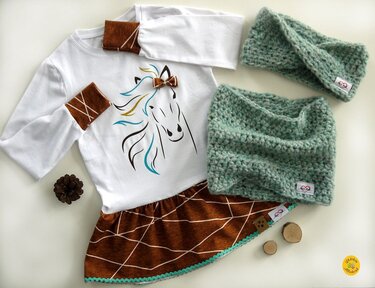 Weißes Langarmshirt mit Pferde-Plott, brauner Rock und mintgrüne Häkel-Accessoires