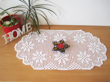 weißes gehäkeltes ovales Tischdeckchen mit floralem Muster, Kerzenhalter und Pflanze