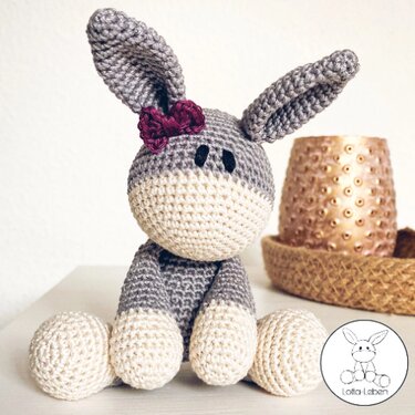 Gehäkeltes graues und cremefarbenes Esel-Amigurumi mit Schleife am Ohr