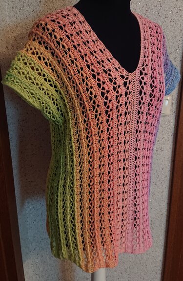 Gehäkelte Damen-Tunika mit V-Ausschnitt in Grün-, Rosa- und Blautönen auf schwarzem Mannequin