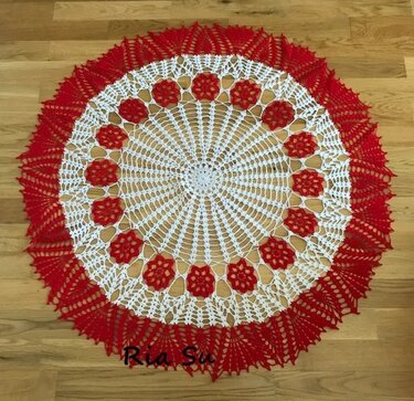 Rundes gehäkeltes Deckchen in Rot und Weiß mit Blütenmuster auf Holzboden