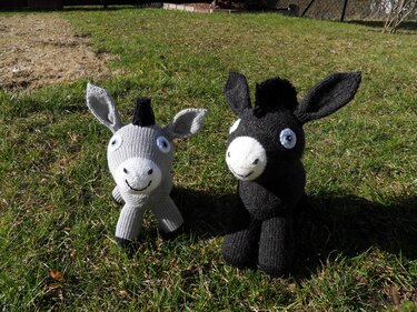 Nahaufnahme von zwei gestrickten Amigurumi-Eseln mit sichtbarer Maschenstruktur