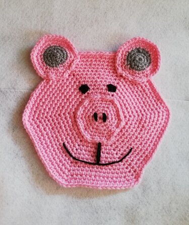 Gehäkelter rosa Topflappen in Form eines Schweins, sechseckig mit Ohren und Schnauze