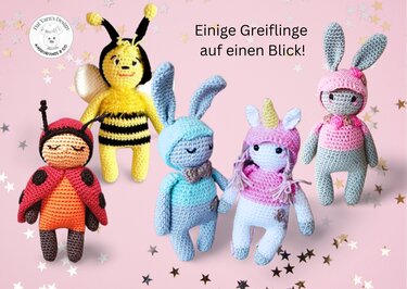 Fünf gehäkelte Amigurumi-Greiflinge (Marienkäfer, Biene, zwei Hasen, Einhorn) auf rosa Hintergrund mit Sternen.