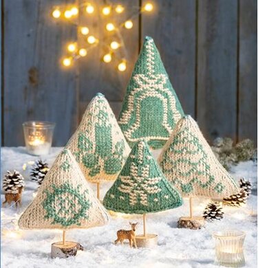 Kegelförmige gestrickte und gehäkelte Weihnachtsbäume in Grün und Creme auf Kunstschnee mit Lichtern und Zapfen