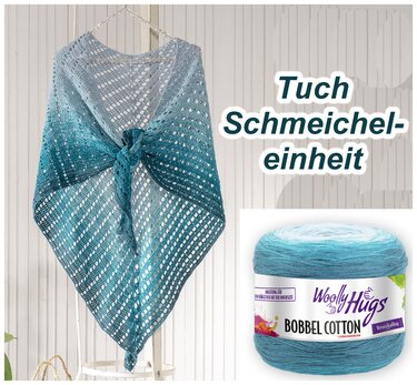 Gehäkeltes dreieckiges Tuch in Türkis-Ombré mit Lochmuster, aufgehängt, daneben ein Garnknäuel