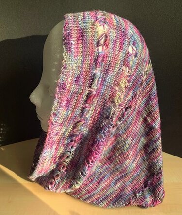 Bunt melierter Loopschal mit Lochmuster auf Schaufensterpuppe