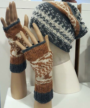 Gestrickte Beanie und fingerlose Stulpen in Grau, Braun und Weiß an Schaufensterpuppen