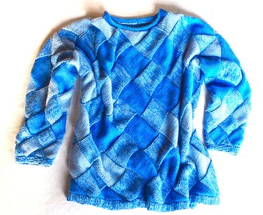 Gestrickter blauer Pullover mit Rautenmuster und langen Ärmeln auf hellem Hintergrund