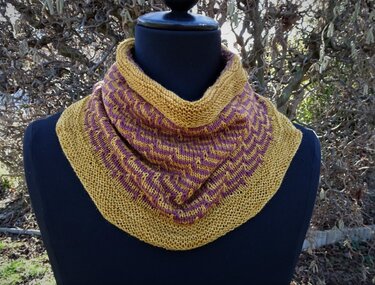 Gestrickter Loop-Schal in Senfgelb und Lila auf schwarzer Schneiderpuppe