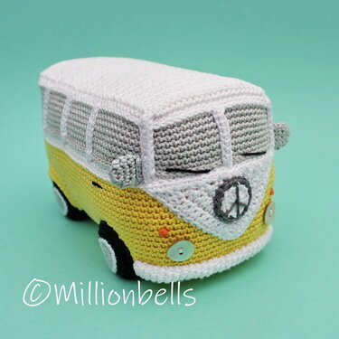 Gehäkeltes Amigurumi: gelb-weißer Retro-Minibus mit rundem Peace-Zeichen Emblem